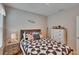 Cozy bedroom features a patterned quilt, accent pillows, and coordinating nightstand and dresser at 1398 Crescent Hoop Way, Wesley Chapel, FL 33543