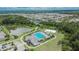 Bird's eye view of a community pool, set amongst lush landscaping, trees and a tranquil pond at 1398 Crescent Hoop Way, Wesley Chapel, FL 33543