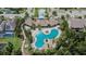 Aerial view of a unique community pool with multiple seating areas and tropical landscaping at 1398 Crescent Hoop Way, Wesley Chapel, FL 33543