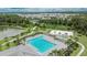 Overhead view of a large community pool with palm trees, a sundeck, and a basketball court for residents at 1398 Crescent Hoop Way, Wesley Chapel, FL 33543