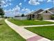 Well-kept lawn and tidy landscaping surround the home, complemented by a white fenced backyard at 1398 Crescent Hoop Way, Wesley Chapel, FL 33543