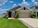 Charming single-Gathering home featuring a well-manicured lawn and attached two-car garage at 1398 Crescent Hoop Way, Wesley Chapel, FL 33543