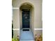 Charming front door with decorative wreath, framed by a welcoming entryway and colorful foliage at 1398 Crescent Hoop Way, Wesley Chapel, FL 33543