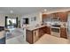Modern kitchen with stainless steel appliances and granite countertops, flowing into the cozy living room at 1398 Crescent Hoop Way, Wesley Chapel, FL 33543