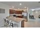Bright kitchen features stainless appliances, bar seating, and granite countertops at 1398 Crescent Hoop Way, Wesley Chapel, FL 33543
