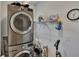 Efficient laundry room with stacked washer and dryer, shelving for supplies, and a practical design at 1398 Crescent Hoop Way, Wesley Chapel, FL 33543