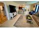 Inviting living room featuring a comfortable sofa, flat screen tv and a view into the kitchen at 1398 Crescent Hoop Way, Wesley Chapel, FL 33543