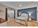 Bedroom featuring a deep blue accent wall and hardwood flooring at 1398 Crescent Hoop Way, Wesley Chapel, FL 33543