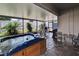 Relaxing screened patio with a luxurious hot tub, dining table, and tranquil backyard view at 1398 Crescent Hoop Way, Wesley Chapel, FL 33543