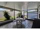 Charming screened patio with a dining set, ambient lighting, and a serene view of the manicured backyard at 1398 Crescent Hoop Way, Wesley Chapel, FL 33543