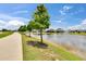 Scenic pond view with walking path and fountain feature at 1398 Crescent Hoop Way, Wesley Chapel, FL 33543