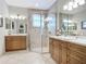 Spacious bathroom featuring a tiled shower, dual vanities with sinks, and neutral color scheme at 15860 Aurora Lake Cir, Wimauma, FL 33598
