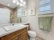 Bathroom with single vanity, decor, framed art, and a shower with tiled walls at 15860 Aurora Lake Cir, Wimauma, FL 33598