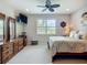 Well-lit bedroom with a ceiling fan, a large window, and a light-colored carpet at 15860 Aurora Lake Cir, Wimauma, FL 33598