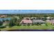 Inviting home exterior with a well-manicured lawn and lush, tropical landscaping, situated on a waterfront lot at 15860 Aurora Lake Cir, Wimauma, FL 33598