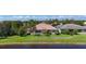Inviting home exterior with a well-manicured lawn and lush, tropical landscaping, situated on a waterfront lot at 15860 Aurora Lake Cir, Wimauma, FL 33598