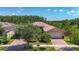 Beautiful single-story home with brick driveway and lush landscaping under a sunny sky at 15860 Aurora Lake Cir, Wimauma, FL 33598