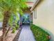 Inviting front porch with seating area, lush landscaping, and brick pathway at 15860 Aurora Lake Cir, Wimauma, FL 33598