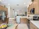 Well-lit kitchen featuring stainless steel appliances, light wood cabinets, and a mosaic backsplash at 15860 Aurora Lake Cir, Wimauma, FL 33598