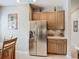 Well-equipped kitchen with stainless steel appliances, light cabinetry and a refrigerator at 15860 Aurora Lake Cir, Wimauma, FL 33598