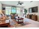 Spacious living room with a ceiling fan, a decorative rug, and access to a sunroom at 15860 Aurora Lake Cir, Wimauma, FL 33598