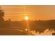 Beautiful sunrise over the water in a warm orange glow, creating a peaceful and serene atmosphere at 15860 Aurora Lake Cir, Wimauma, FL 33598