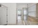 Bright bathroom with a glass-enclosed shower and neutral tile, leading into an open hallway with natural light at 17668 Bright Wheat Dr, Lithia, FL 33547