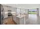 Contemporary kitchen and living area with stainless steel appliances and breakfast bar seating at 17668 Bright Wheat Dr, Lithia, FL 33547