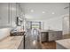 Modern kitchen with stainless steel appliances, granite countertops, and an island overlooking a dining area and backyard at 17668 Bright Wheat Dr, Lithia, FL 33547