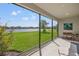 Enclosed lanai offering serene views of a lush green lawn and a tranquil lake at 17668 Bright Wheat Dr, Lithia, FL 33547