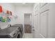 Well-equipped laundry room with modern washer and dryer, built-in shelving, and access to a walk-in closet at 17668 Bright Wheat Dr, Lithia, FL 33547