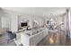 Bright, open living area featuring modern furniture and a seamless flow to the dining and kitchen spaces at 17668 Bright Wheat Dr, Lithia, FL 33547