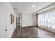 Flexible living space featuring dark wood floors, bright window with decorative curtains, and neutral walls to add your style at 17668 Bright Wheat Dr, Lithia, FL 33547