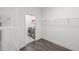 Generous walk-in closet with wood-look floors, wire shelving, and a glimpse into a laundry room with modern appliances at 17668 Bright Wheat Dr, Lithia, FL 33547