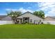 Sprawling backyard with lush green lawn, mature trees, and a white fence for privacy at 1806 Powder Ridge Dr, Valrico, FL 33594