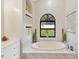 Elegant bathroom with a soaking tub, marble countertop, and stylish decor at 1806 Powder Ridge Dr, Valrico, FL 33594