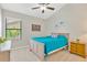 Cozy bedroom with a blue bed, ceiling fan, and a bright window overlooking the yard at 1806 Powder Ridge Dr, Valrico, FL 33594