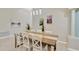 Dining room with a long wood table, white chairs, and modern light fixture at 1806 Powder Ridge Dr, Valrico, FL 33594