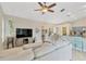 Bright living room featuring a ceiling fan, large TV, and an open view to the kitchen at 1806 Powder Ridge Dr, Valrico, FL 33594