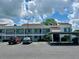 Exterior view of condo building with carport and parking spaces on a sunny day at 2060 Marilyn St # 121, Clearwater, FL 33765