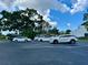 View of parking lot with parked vehicles under a sunny, partly cloudy sky at 2060 Marilyn St # 121, Clearwater, FL 33765