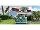 Exterior view of community sign with lush landscaping and well-maintained buildings at 2060 Marilyn St # 121, Clearwater, FL 33765