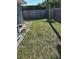 Fenced backyard with grass and a partial view of the pool equipment area at 2198 Academy Dr, Clearwater, FL 33764