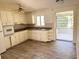 Functional kitchen with white cabinets, tiled backsplash, and abundant natural light at 2271 Terrace N Dr, Clearwater, FL 33765