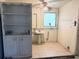 Spacious utility room with a laundry sink, storage cabinet, and tile flooring at 2271 Terrace N Dr, Clearwater, FL 33765