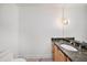 Half bath features a granite countertop, wood cabinet, decorative mirror, and tile flooring at 2309 Cypress Walk Way, Ruskin, FL 33570
