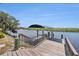 Dock with a boat lift overlooking the scenic canal with lush surroundings at 2309 Cypress Walk Way, Ruskin, FL 33570