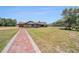 Sprawling property showcases the house and pool area from the yard's entrance at 2309 Cypress Walk Way, Ruskin, FL 33570