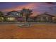 Stunning two-story home at sunset featuring brick accents, mature trees, fountain, and a brick driveway at 2309 Cypress Walk Way, Ruskin, FL 33570