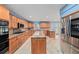 Large kitchen with stainless steel appliances, granite countertops, a center island, and wood cabinets at 2309 Cypress Walk Way, Ruskin, FL 33570